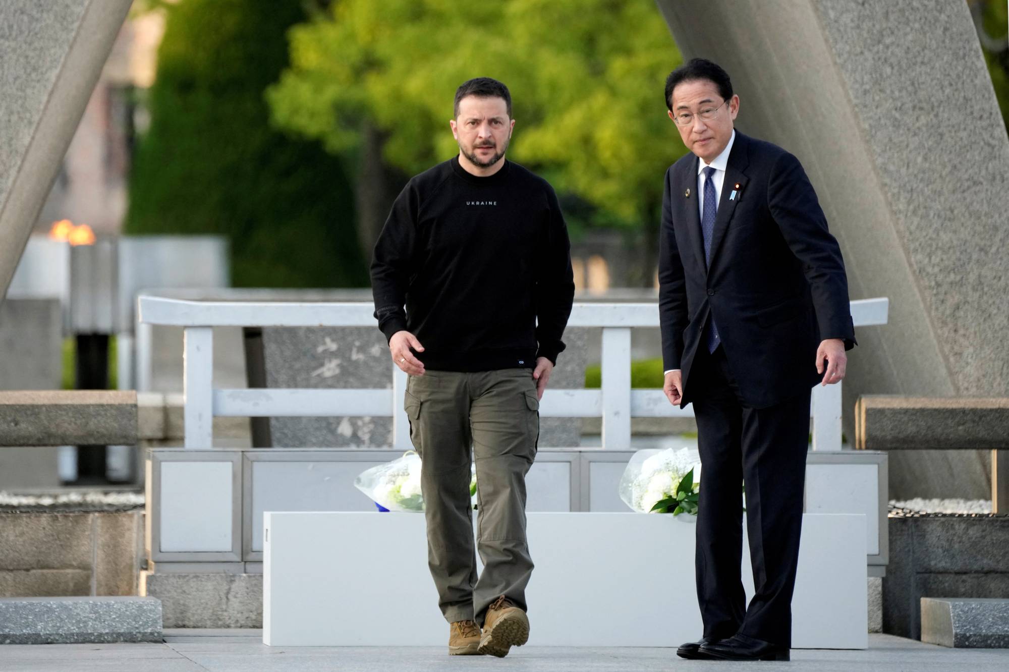 Zelenskyy is escorted by Prime Minister Fumio Kishida after laying flowers in front of the Cenotaph for the Victims of the Atomic Bomb at the Hiroshima Peace Memorial Park on Sunday.  | Pool / via Reuters 