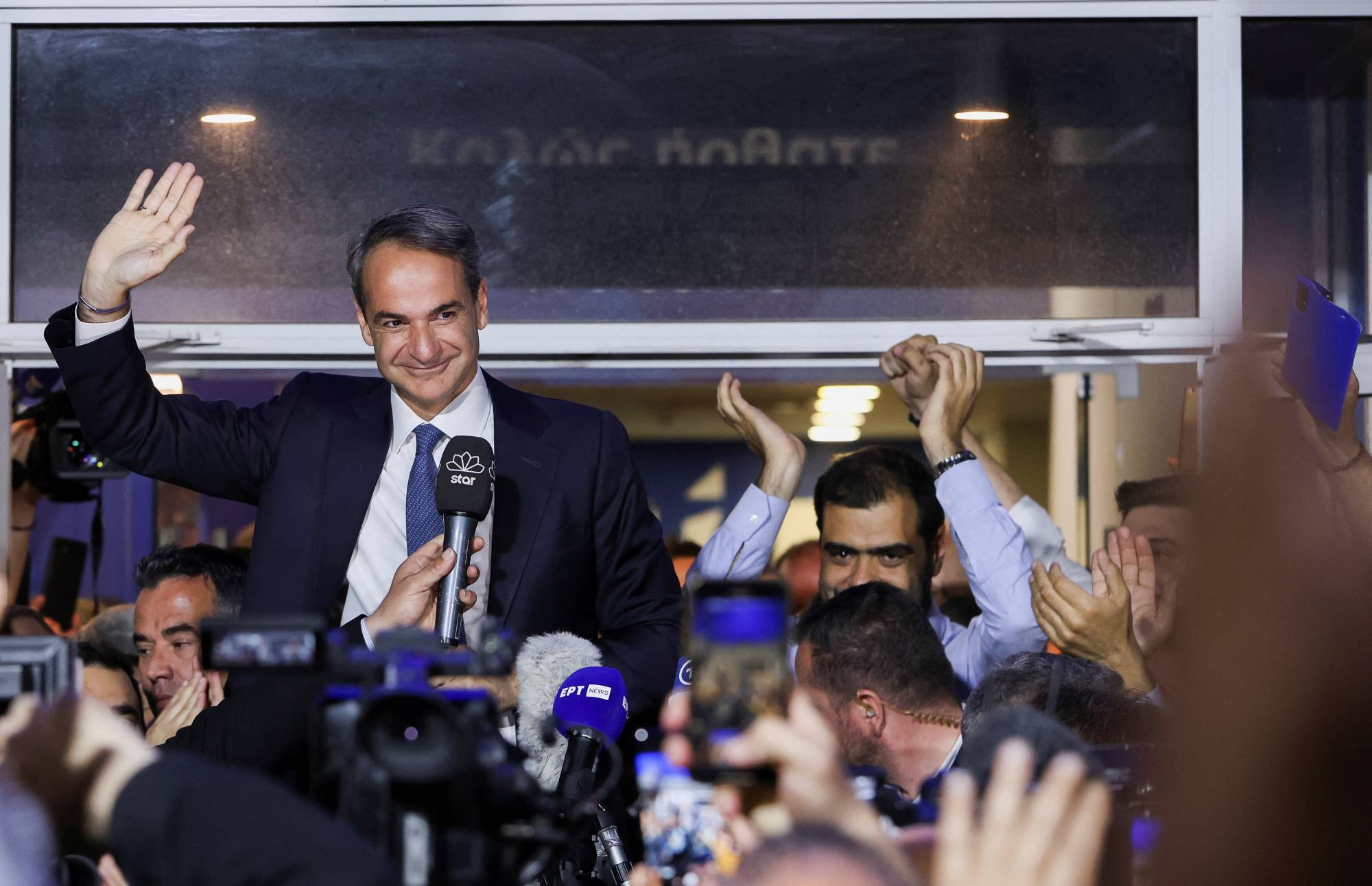 Greek Prime Minister and New Democracy conservative party leader Kyriakos Mitsotakis waves outside the party's headquarters in Athens on Sunday, after a general election. | REUTERS