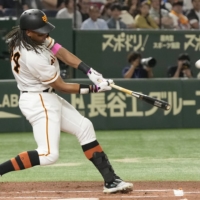 The Giants\' Adam Walker hits a two-run homer against the Dragons at Tokyo Dome on Sunday. | KYODO