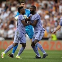 Real Madrid\'s Vinicius Junior (left) is restrained by teammates after being sent off during his team\'s match against Valencia at Mestalla Stadium in Valencia, Spain, on Sunday. | REUTERS