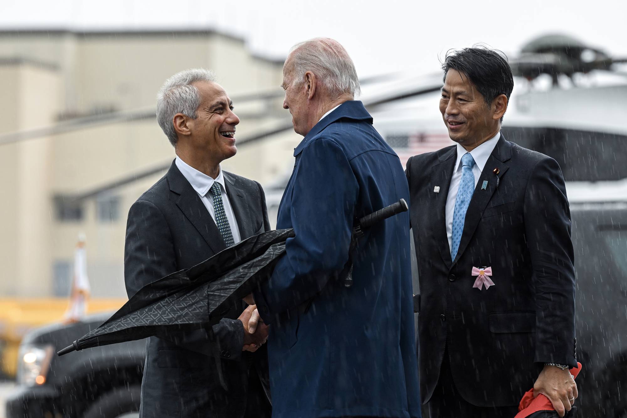 U.S. President Joe Biden (center), is greeted by Rahm Emanuel, the U.S. ambassador to Japan, at Marine Corps Air Station Iwakuni in Japan on May 18. | KENNY HOLSTON / THE NEW YORK TIMES