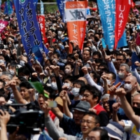 Members of the Japanese Trade Union Confederation, commonly known as Rengo, raise their fists during their annual May Day rally in Tokyo to demand higher pay. | REUTERS