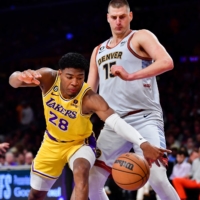 Lakers forward Rui Hachimura (left) dives for a loose ball against Nuggets center Nikola Jokic during the third quarter in Game 4 of the Western Conference finals in Los Angeles on Monday. | USA TODAY / VIA REUTERS