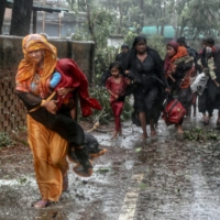 People evacuate from their homes to the nearest shelter as Cyclone Mocha makes landfall in Teknaf, Bangladesh, on May 14. | REUTERS