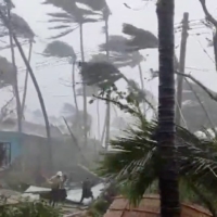 People brave the strong winds and rain caused by Cyclone Mocha in Sittwe, Myanmar, in this screen grab from a handout video released on May 14. | PARTNERS RELIEF AND DEVELOPMENT / VIA REUTERS   