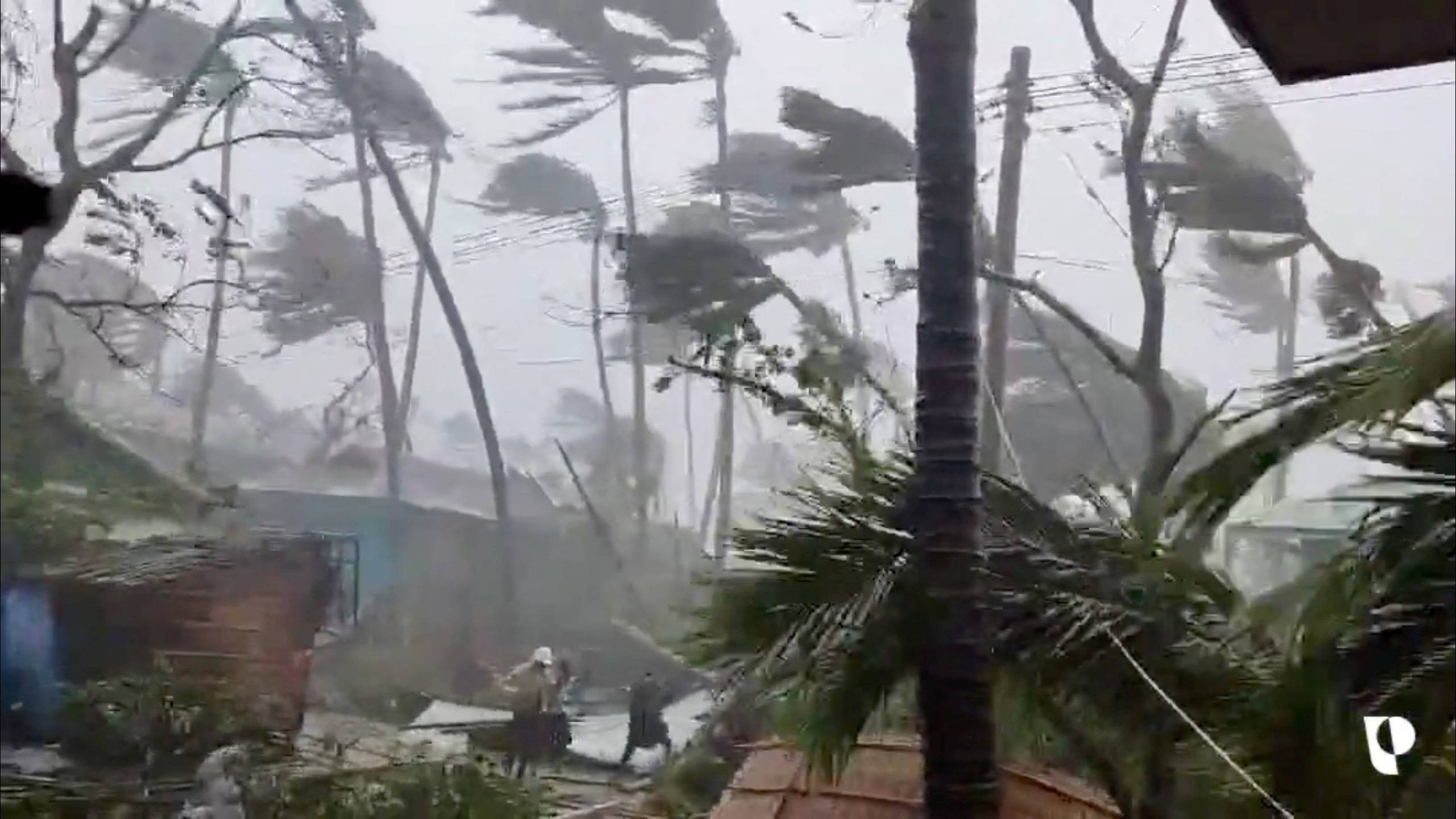 People brave the strong winds and rain caused by Cyclone Mocha in Sittwe, Myanmar, in this screen grab from a handout video released on May 14. | Partners Relief and Development / via REUTERS 