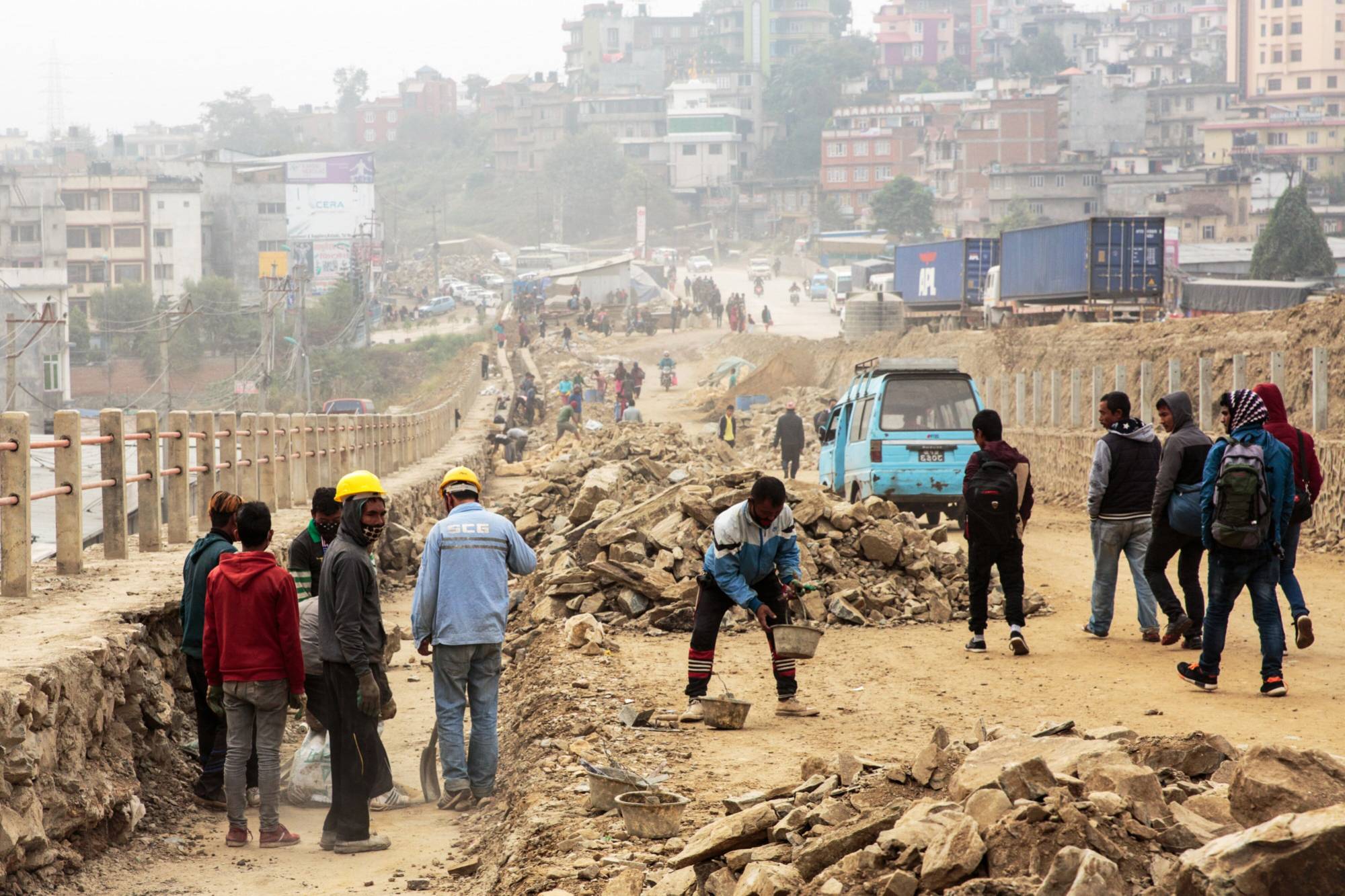 Workers labor on a construction site for a road, operated by Shanghai Construction Group, in the Kalanki Chowk area of Kathmandu in November 2017. India and China have often jostled for influence in Nepal, a nation sandwiched between the two Asian giants. | BLOOMBERG