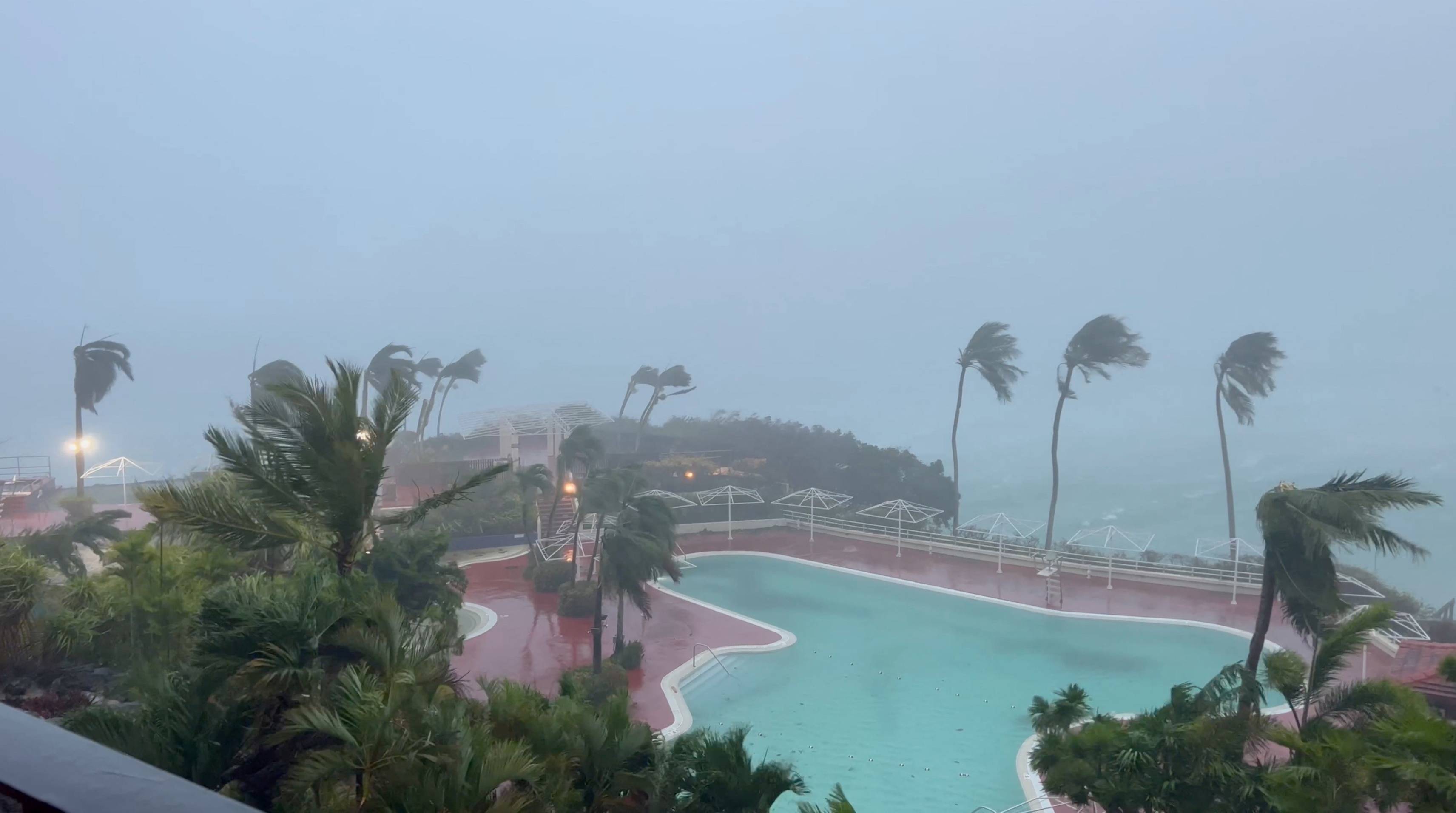 Trees sway due to strong winds from typhoon Mawar, in Tamuning, Guam, on Wednesday, in this screen grab obtained from social media.  | M.F. Peoples / via REUTERS  