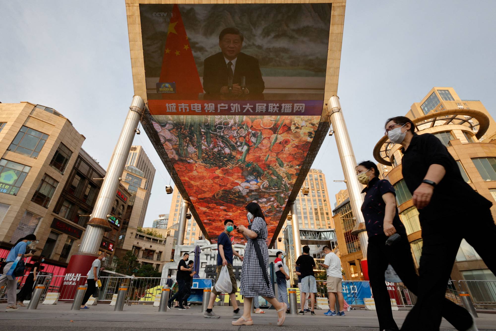 Screens above a shopping center in Beijing broadcast Chinese President Xi Jinping addressing the BRICS Business Forum via video link in June last year. | REUTERS