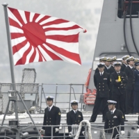 A rising sun flag, the Maritime Self-Defense Force\'s official ensign, is flown on the deck of the destroyer Suzutsuki as it arrived at China\'s Qingdao port on April 21, 2019, to attend a fleet review conducted by the Chinese navy to mark the 70th anniversary of its foundation. | KYODO
