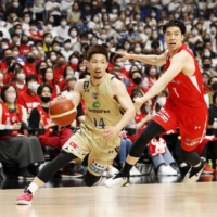 Ryukyu swingman Keita Imamura (left) attacks the Jets basket during the first quarter at Yokohama Arena on Saturday. | KYODO