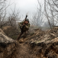 A Ukrainian soldier fires a rocket-propelled grenade at Russian forces near Bakhmut, Ukraine, on March 20. | TYLER HICKS / THE NEW YORK TIMES