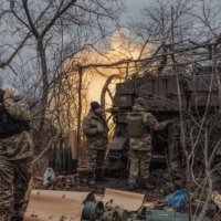 Ukrainian soldiers fire artillery rounds toward a Russian infantry position near Bakhmut, Ukraine, on March 3. | DANIEL BEREHULAK / THE NEW YORK TIMES