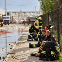 Firefighters rest after a medical facility was hit by a missile, in the city of Dnipro, Ukraine, on Friday. | AFP-JIJI