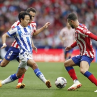 Real Sociedad\'s Takefusa Kubo (left) kicks the ball during the first half of his team\'s away match against Atletico Madrid on Sunday. | KYODO