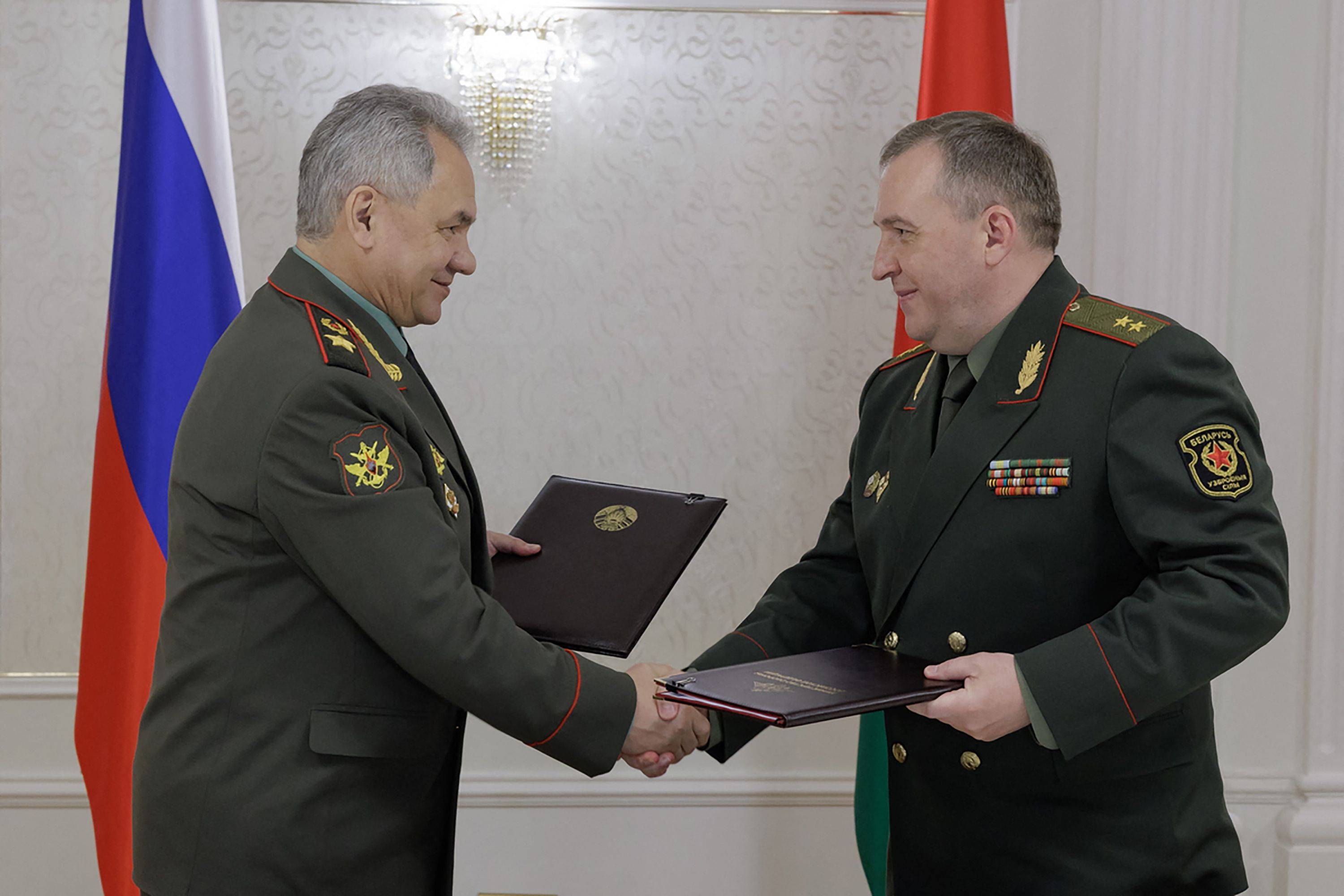 Russian Defense Minister Sergei Shoigu and his Belarusian counterpart, Viktor Khrenin, shake hands after signing an agreement on the deployment of Russian nuclear-capable weapons to Belarus, in Minsk, Belarus, on Thursday. | Russian Defense Ministry / VIA AFP-JIJI