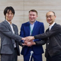 Chigiru Yamashita (left), chief of the Japan International Cooperation Agency\'s law and justice team, Public Broadcasting Company of Ukraine Chairman Mykola Chernotytskyi (center) and NHK Foundation executive Hiroshi Yamamoto shake hands at the NHK Broadcasting Center in Tokyo on Monday. | ANIKA OSAKI EXUM