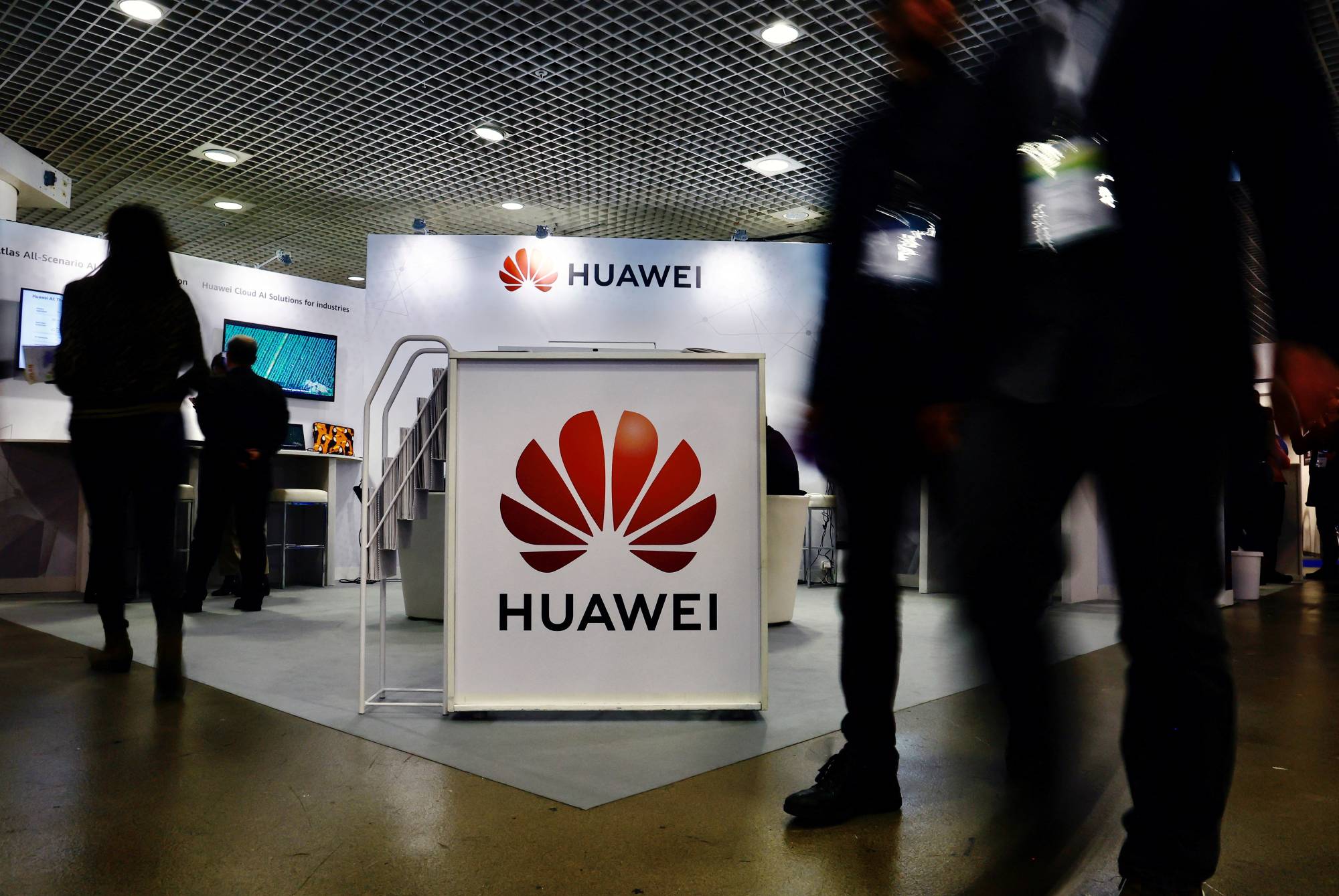 Visitors walk past the Huawei logo at the World Artificial Intelligence Cannes Festival in Cannes, France, on Feb.10. | REUTERS
