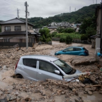 Cars are seen trapped in the mud following flooding and landslides in Saka, Hiroshima Prefecture, in 2018. | AFP-JIJI