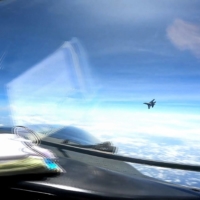 A screenshot made from video taken on May 26 shows a Chinese J-16 fighter jet flying in front of the nose of a U.S. Air Force RC-135 reconnaissance aircraft in international airspace over the South China Sea. | DVIDS / VIA AFP-JIJI