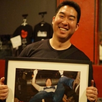 Steven Tanaka holds a framed picture of himself crowdsurfing.  | COURTESY OF STEVEN TANAKA
