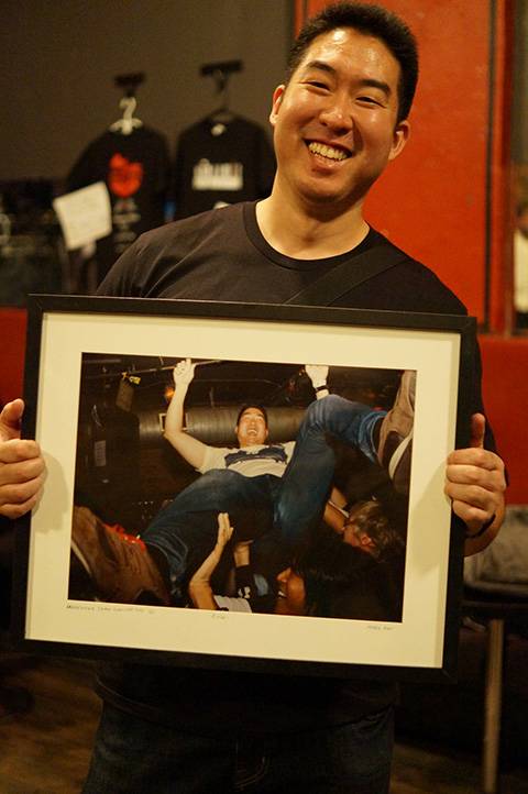 Steven Tanaka holds a framed picture of himself crowdsurfing. | COURTESY OF STEVEN TANAKA 