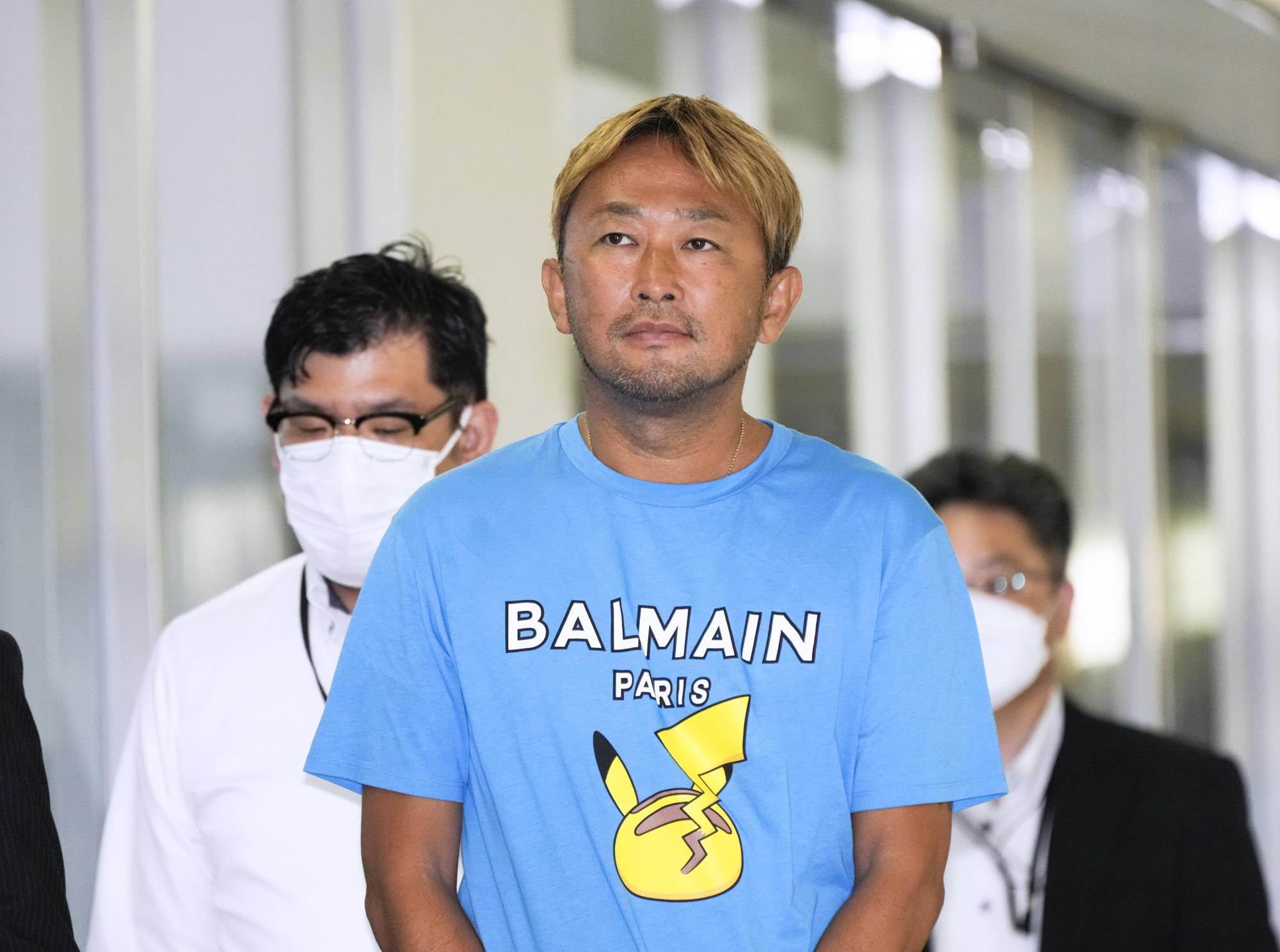 Yoshikazu Higashitani, known as GaaSyy, is arrested after arriving at Narita Airport on Sunday evening.   | KYODO