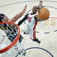 Heat center Bam Adebayo attempts a shot against the Nuggets\' Aaron Gordon during Game 2 of the NBA Finals at Ball Arena in Denver on Sunday. | USA TODAY / VIA REUTERS
