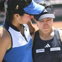 Miyu Kato (right) is consoled by her partner Aldila Sutjiadi after being disqualified in the third round of the women\'s doubles competition at the French Open on Sunday. | KYODO