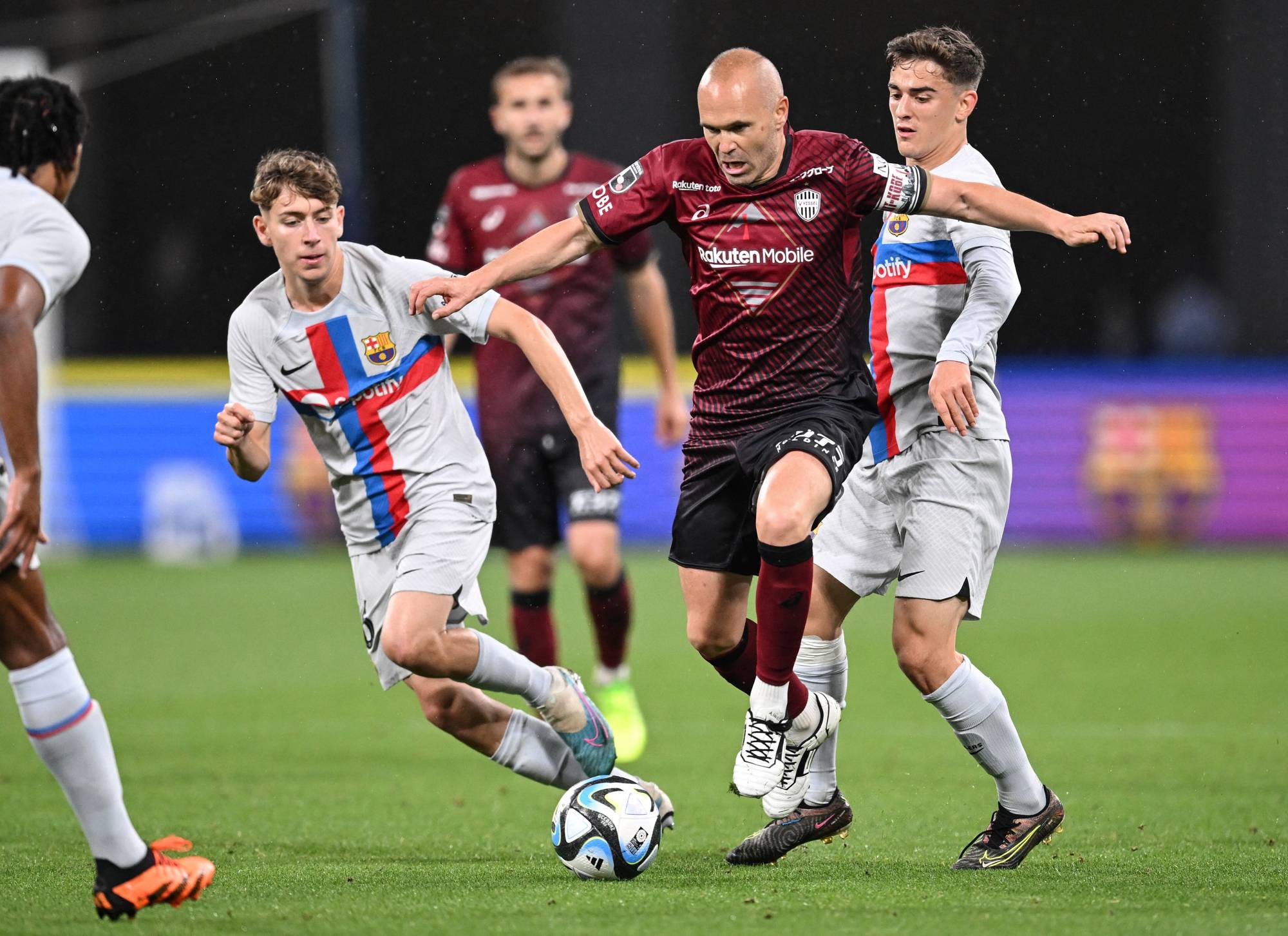 Vissel Kobe midfielder Andres Iniesta (center) attacks the Barcelona goal during an international friendly at Tokyo's National Stadium on Tuesday. | AFP-JIJI