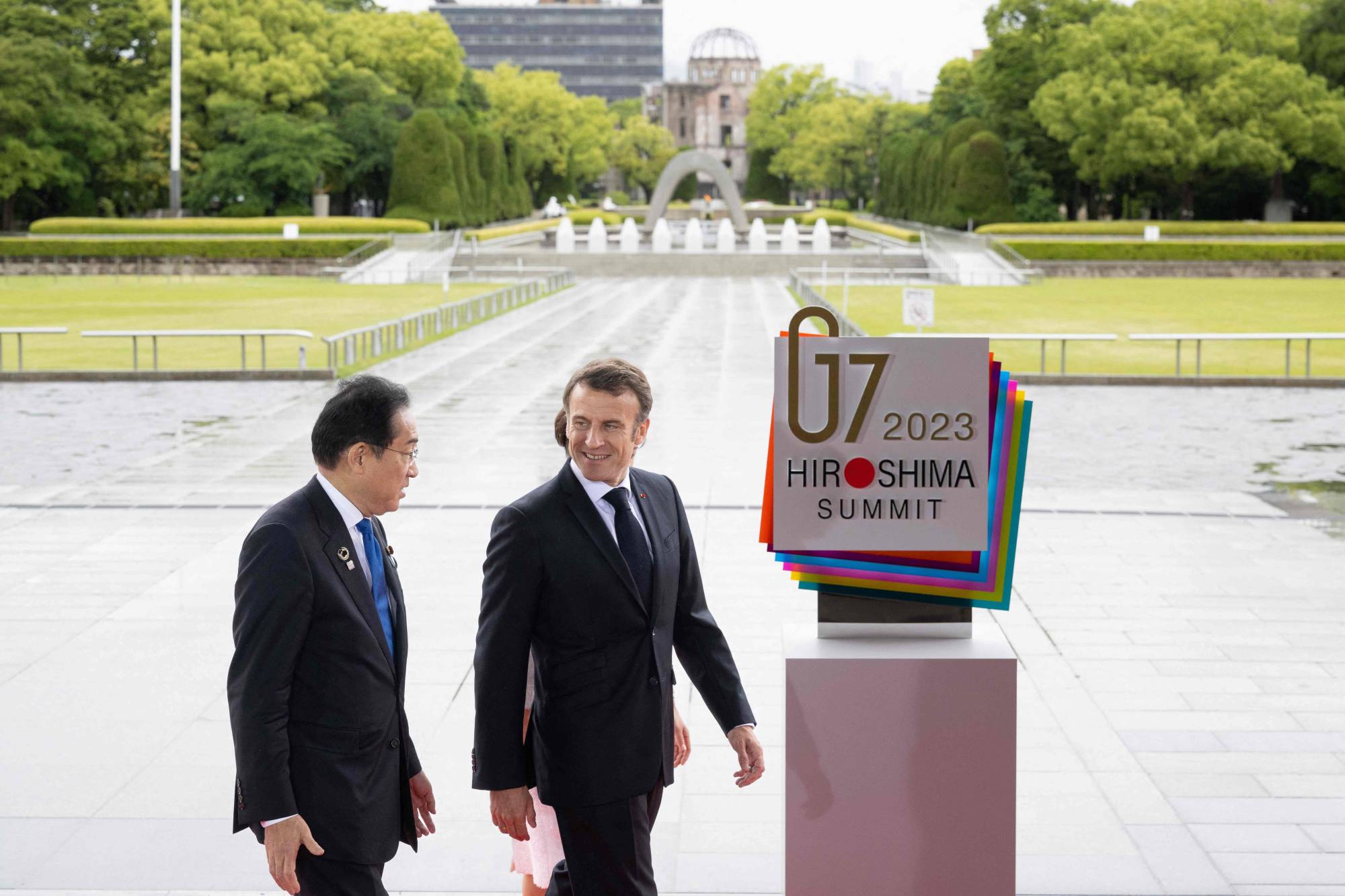 Prime Minister Fumio Kishida (left) welcomes France's President Emmanuel Macron at the Peace Memorial Park as part of the Group of Seven Leaders' Summit in Hiroshima last month. | POOL / VIA AFP-JIJI