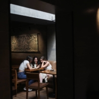 Customers sit at a Starbucks\' outlet at a market in New Delhi, on May 30. | REUTERS
