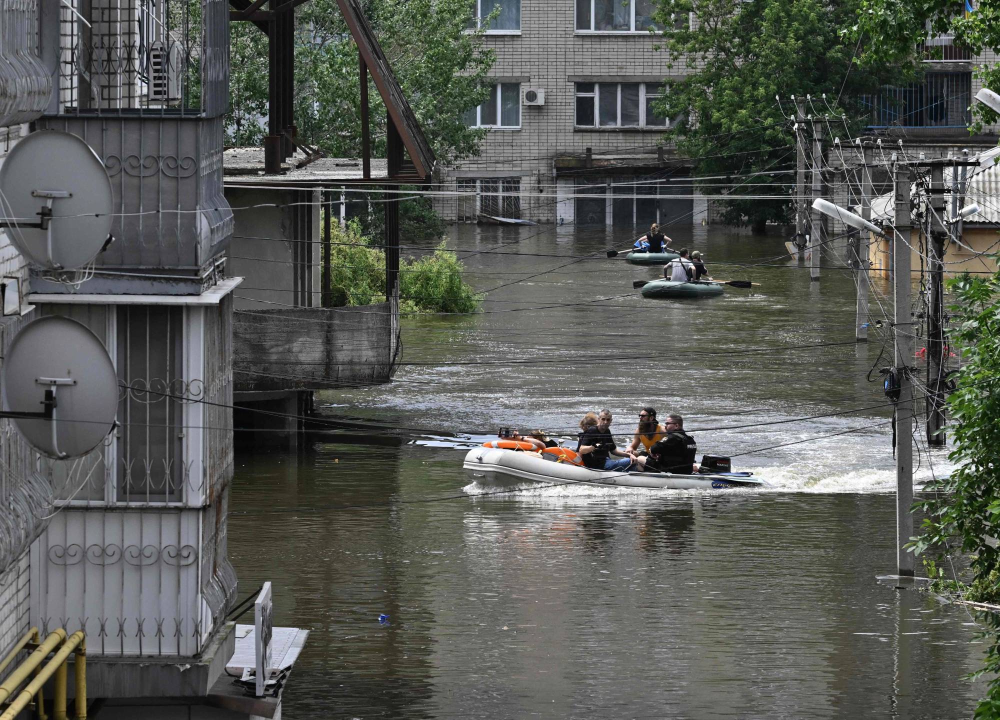Volunteers sail on boats while evacuating from a flooded area in Kherson, Ukraine, on Thursday, following damage sustained at the Kakhovka hydroelectric power plant dam. | AFP-Jiji