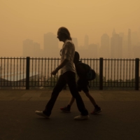 Pedestrians walk amid heavy smoke from wildfires in Canada on the Brooklyn Heights promenade in New York on Wednesday. | EARL WILSON / THE NEW YORK TIMES