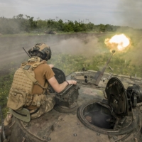 A soldier with the 28th Mechanized Brigade, positioned near Bakhmut, Ukraine, fire on Russian positions from an infantry fighting vehicle, on Saturday. 
  | TYLER HICKS / THE NEW YORK TIMES