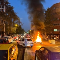 A police motorcycle burns during a protest over the death of Mahsa Amini, a woman who died after being arrested by the Islamic republic\'s \"morality police,\" in Tehran, on Sept. 19, 2022. | WEST ASIA NEWS AGENCY / VIA REUTERS 