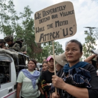 Tribal women, mostly Kukis, form a human chain along the route that the home minister Amit Shah would take during a visit, in Churachandpur, in the Indian state of Manipur, May 30. | SAUMYA KHANDELWAL / THE NEW YORK TIMES