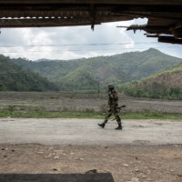 A member of the Border Security Force along the road to one of the last Meitei villages in Imphal East, in the Indian state of Manipur, on June 1. | SAUMYA KHANDELWAL / THE NEW YORK TIMES