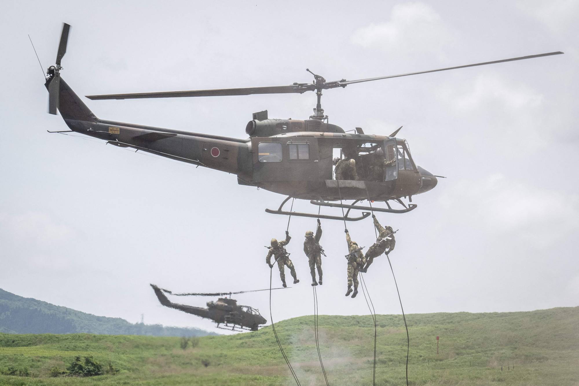 Ground Self-Defense Forces soldiers rappel from a helicopter during a live-fire exercise at the East Fuji Maneuver Area in Gotemba, Shizuoka Prefecture, on May 27. | AFP-JIJI