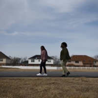 A mother and her daughter take the family dog for a walk around the neighborhood in Matteson, Illinois, in March 2022. The father died from COVID-19 in May 2020. | REUTERS