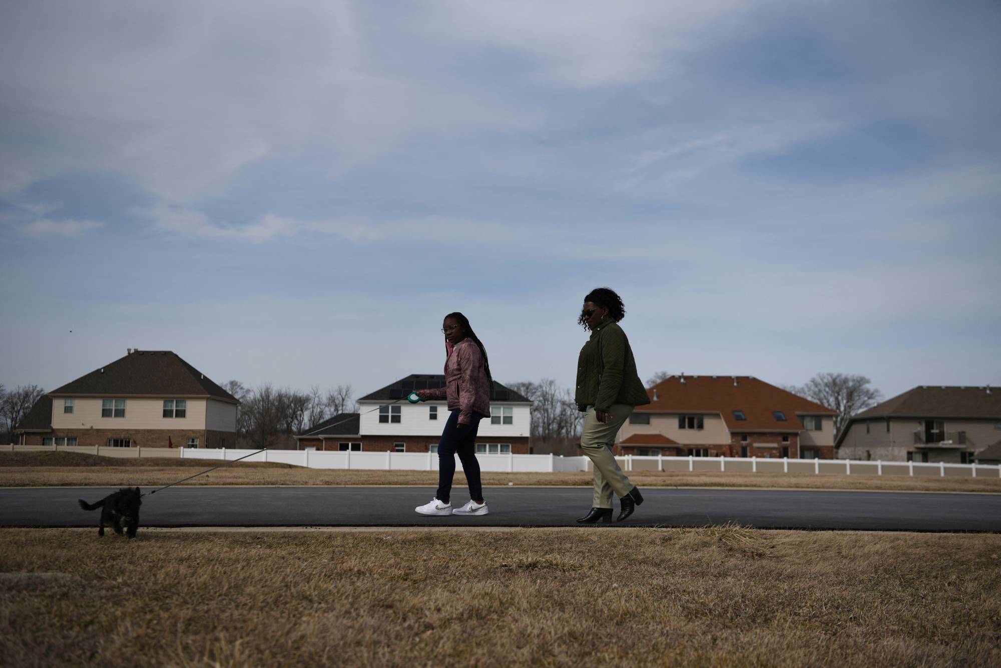 A mother and her daughter take the family dog for a walk around the neighborhood in Matteson, Illinois, in March 2022. The father died from COVID-19 in May 2020. | REUTERS