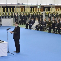 Prime Minister Fumio Kishida delivers a speech during a memorial service held in the city of Kumamoto Sunday for the 10 victims of a Ground Self-Defense Force helicopter crash in April. | GSDF WESTERN ARMY / VIA KYODO