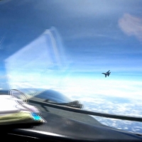 A Chinese military J-16 fighter jet flies in front of the nose of a U.S. Air Force RC-135 reconnaissance aircraft in international airspace over the South China Sea on May 26. | DVIDS / VIA AFP-JIJI