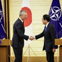 Stoltenberg and Kishida shake hands after holding a joint media briefing on Jan. 31. | POOL / VIA REUTERS