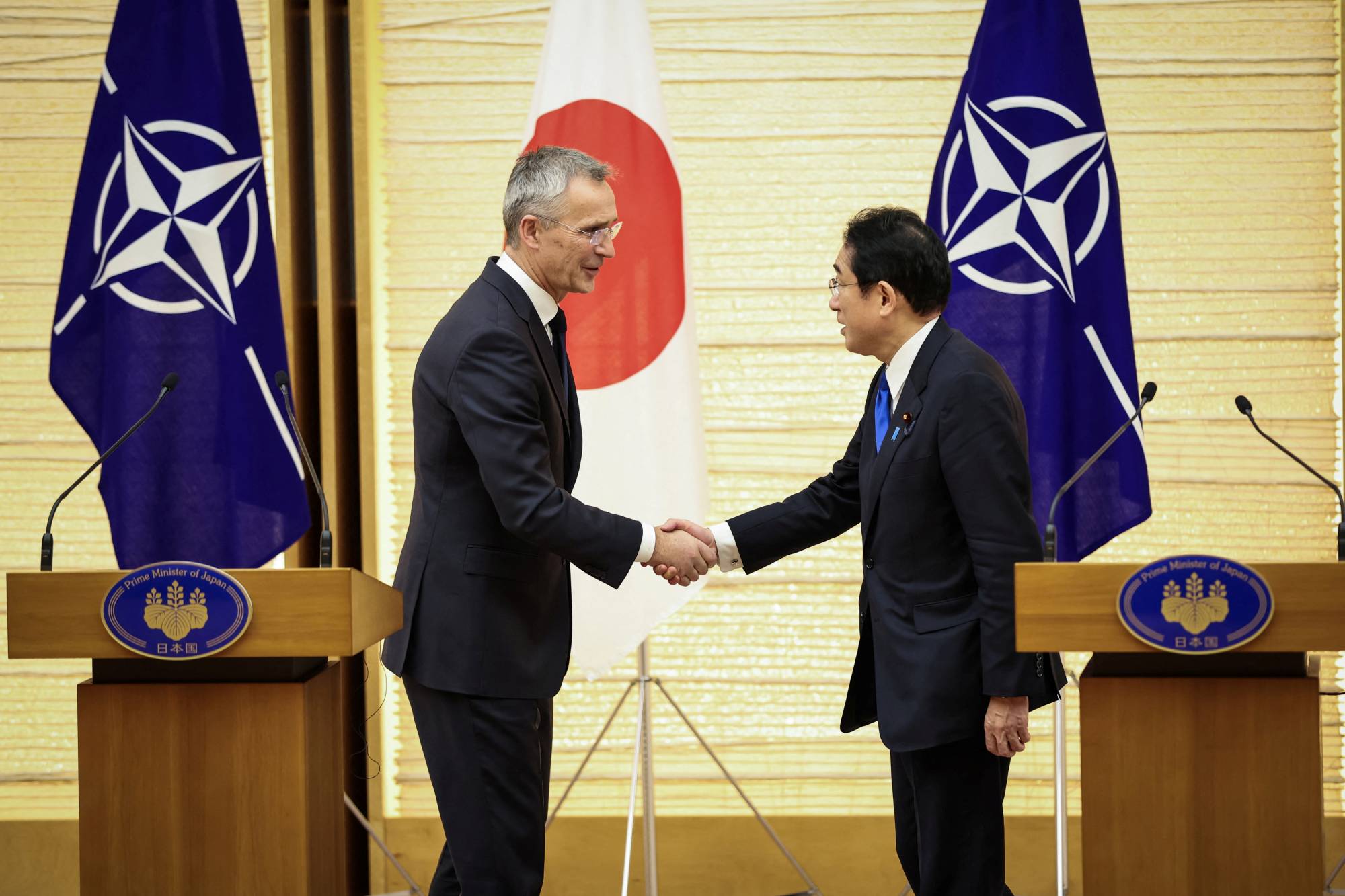 Stoltenberg and Kishida shake hands after holding a joint media briefing on Jan. 31. | Pool / via REUTERS