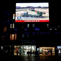 A giant screen displays news footage of military vehicles under the Eastern Theatre Command of China\'s People\'s Liberation Army taking part in joint military exercises around Taiwan, at a shopping mall in Beijing on April 10. | REUTERS