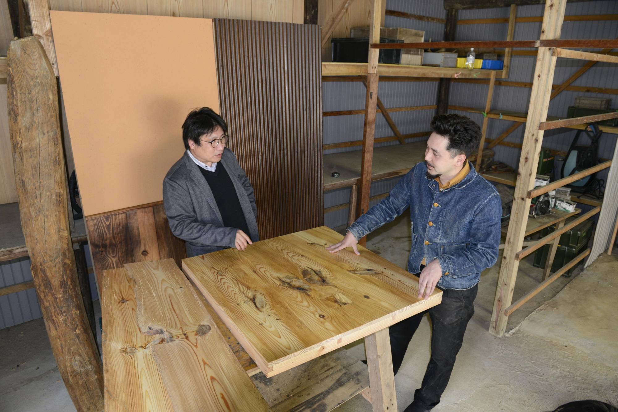 Motoki Moriyama (left) and Hajime Wilds discuss ideas for commercialization, such as creating panels from old wood, in Shimane Prefecture on March 29. | KYODO