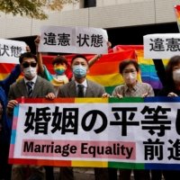 Plaintiffs hold placards outside a Tokyo court after hearing a ruling on same-sex marriage in November.  | REUTERS