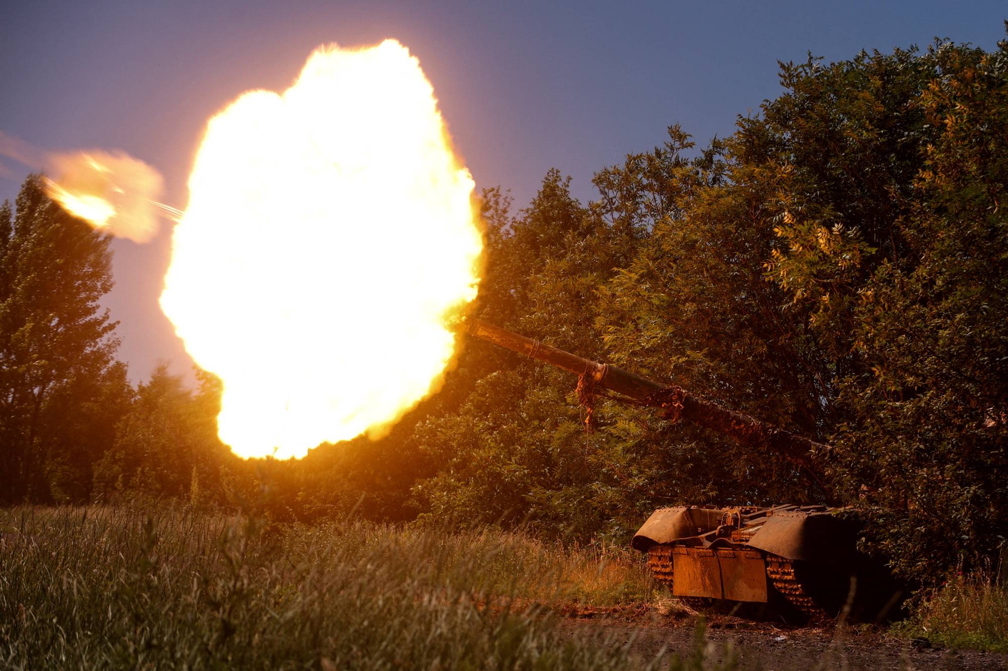 Ukrainian servicemen fire from a T-80 main battle tank captured earlier from Russian troops, in a field near the front line town of Bakhmut. | Radio Free Europe / Radio Liberty / via REUTERS 