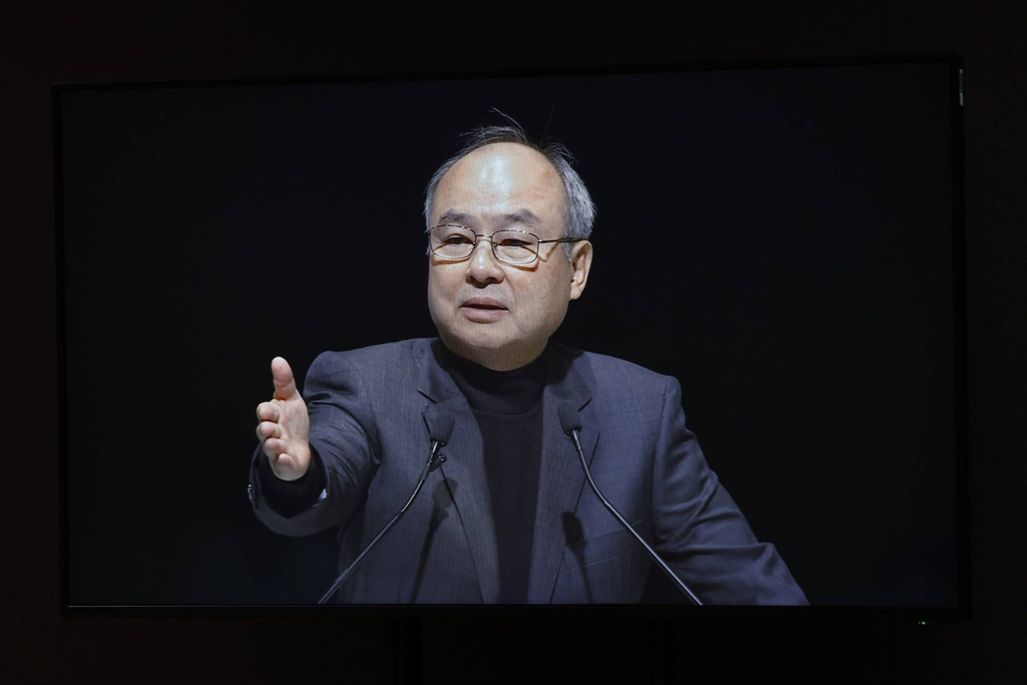 Masayoshi Son, chairman and chief executive officer of SoftBank Group, is displayed on a monitor while speaking during the company's annual general meeting in Tokyo on Wednesday. | BLOOMBERG